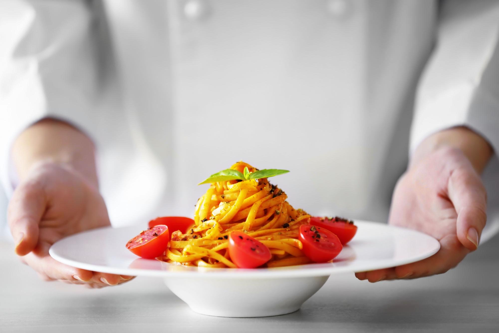 Chef plating a simple pasta dish